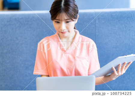 カルテの情報をパソコンに登録する若い女性 100734225