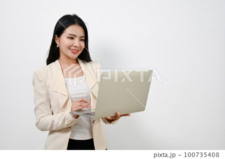Attractive Asian businesswoman using her laptop. isolated white background. 100735408