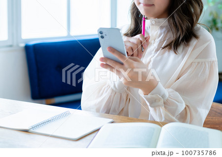 スマホを使って勉強する女性【パーツカット】 スマホを使って勉強する女性【パーツカット】 100735786