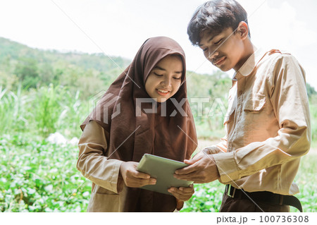 boy scout teens and girl scouts using tablets together 100736308