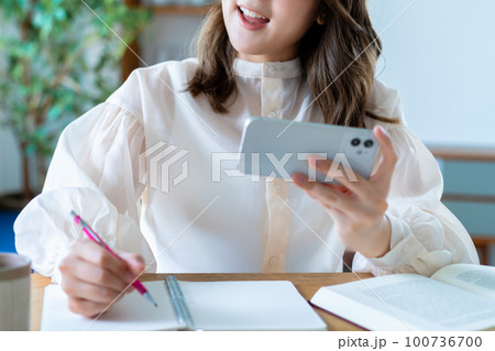 スマホの動画を観て勉強する女性【パーツカット】 スマホの動画を観て勉強する女性【パーツカット】 100736700