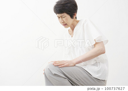 膝が痛む中年女性 白背景 膝が痛む中年女性 白背景 100737627