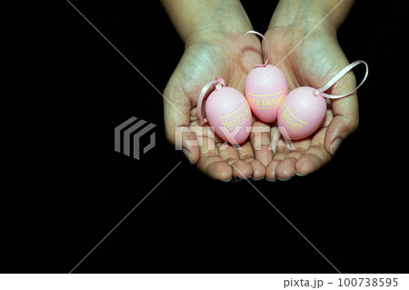 Two hands holding pink color happy easter wording on eggs Two hands holding pink color happy easter wording on eggs 100738595