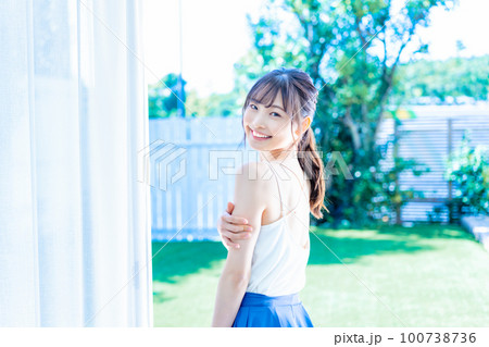 庭の新緑でリフレッシュする若い女性 庭の新緑でリフレッシュする若い女性 100738736