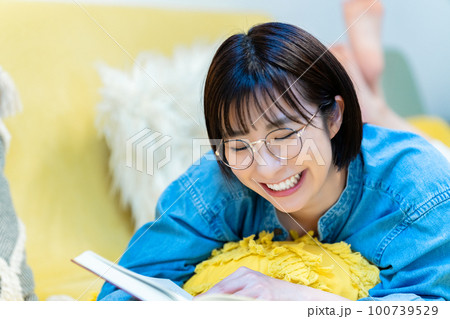 ソファーに寝転んで本を読む女性 ソファーに寝転んで本を読む女性 100739529