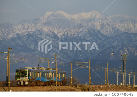 立山連峰と夕日に輝くあいの風とやま鉄道521系電車 立山連峰と夕日に輝くあいの風とやま鉄道521系電車 100740045