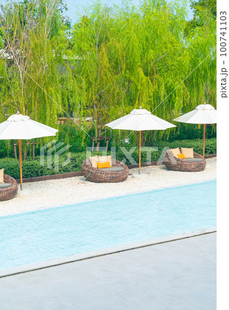 outdoor patio chair with pillow and umbrella around swimming pool 100741103