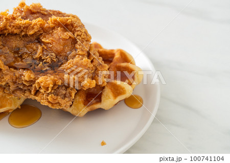 fried chicken waffle with honey or maple syrup 100741104