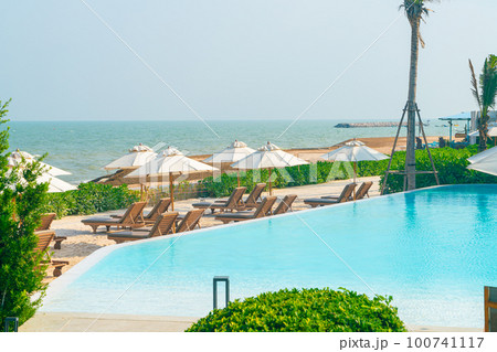 umbrella with bed pool around swimming pool with ocean sea background umbrella with bed pool around swimming pool with ocean sea background 100741117