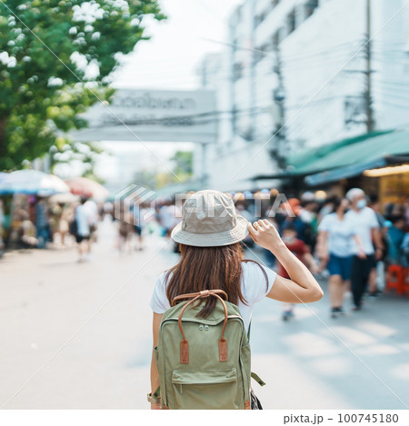 woman traveler visiting in Bangkok, Tourist with backpack and hat sightseeing in Chatuchak Weekend Market, landmark and popular attractions in Bangkok, Thailand. Travel in Southeast Asia concept woman traveler visiting in Bangkok, Tourist with backpack and hat sightseeing in Chatuchak Weekend Market, landmark and popular attractions in Bangkok, Thailand. Travel in Southeast Asia concept 100745180