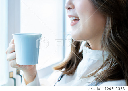 コーヒーを飲む女性の手元【パーツカット】 100745328