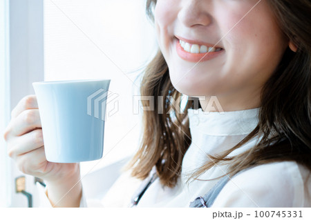 コーヒーを飲む女性の手元【パーツカット】 100745331