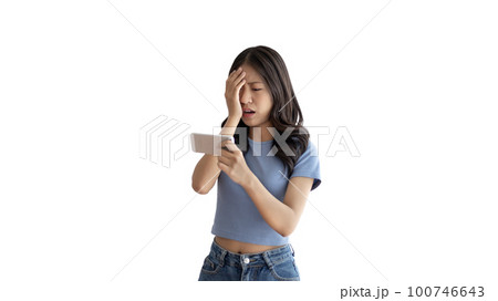 Young woman looking frustrated or depressed after losing playing games on mobile phone, Playing Games On Smartphone, Make an angry face and frown, Upset, Lost bet. 100746643