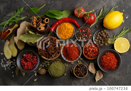 Set of spices and herbs. Indian food. Pepper, salt, paprika, basil, turmeric. On a black wooden board. View from above. Free copy space. 100747238