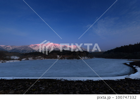 朝日に焼けた禿岳と氷結したかむろ湖 朝日に焼けた禿岳と氷結したかむろ湖 100747332