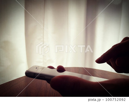 スマホを操作する女性の手元 100752092