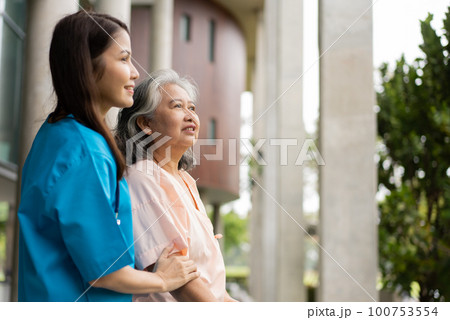 Asian careful caregiver or nurse hold patient hand and encourage patient, walking in garden. Concept of happy retirement with care from a caregiver and Savings and senior health insurance. Asian careful caregiver or nurse hold patient hand and encourage patient, walking in garden. Concept of happy retirement with care from a caregiver and Savings and senior health insurance. 100753554