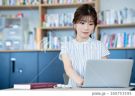 図書館でノートパソコンを使う若い女性 図書館でノートパソコンを使う若い女性 100753595
