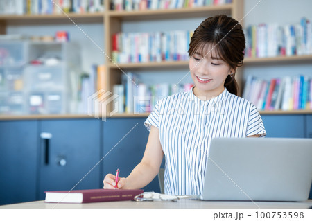 図書館でノートパソコンを使う若い女性 図書館でノートパソコンを使う若い女性 100753598