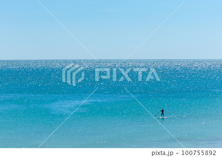 美しい海でSUP(サップ)を楽しむ人物のシルエット 美しい海でSUP(サップ)を楽しむ人物のシルエット 100755892