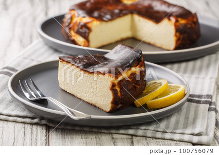 Restaurant style famous burnt San Sebastian cheesecake close-up on a plate. Horizontal Restaurant style famous burnt San Sebastian cheesecake close-up on a plate. Horizontal 100756079