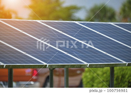 Solar panels installed on stand frame near parking lot for effective generation of clean electricity. Photovoltaic technology integrated in urban infrastructure for electric car charging Solar panels installed on stand frame near parking lot for effective generation of clean electricity. Photovoltaic technology integrated in urban infrastructure for electric car charging 100756981