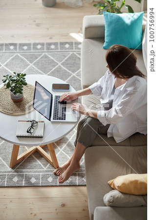 Mockup white screen laptop woman using computer sitting on sofa at home, top view Mockup white screen laptop woman using computer sitting on sofa at home, top view 100756994