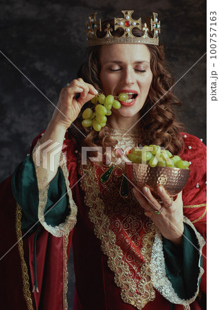 medieval queen in red dress with plate of grapes and crown medieval queen in red dress with plate of grapes and crown 100757163