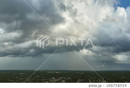 Landscape of dark ominous clouds forming on stormy sky before heavy thunderstorm over rural town area 100758554