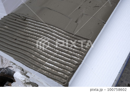 Installation of styrofoam insulation sheets on house facade wall for thermal protection. Installation of styrofoam insulation sheets on house facade wall for thermal protection. 100758602