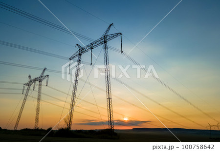 High voltage towers with electric power lines at sunset. High voltage towers with electric power lines at sunset. 100758642