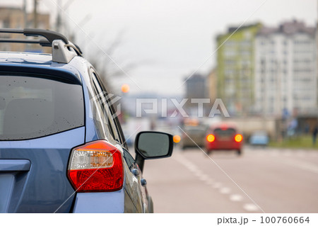 Closeup of rear headlight of new clean car parked on a city street side. 100760664
