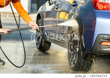 Closeup of male driver washing his car with contactless high pressure water jet in self service car wash. 100760724