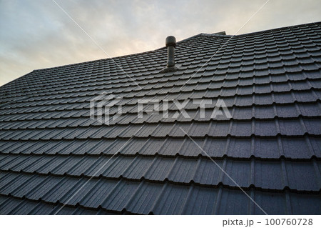 Closeup of house roof top covered with metallic shingles.Tiled covering of building 100760728