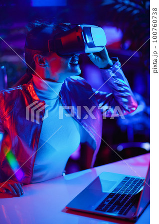 curious stylish female in virtual reality goggles in office curious stylish female in virtual reality goggles in office 100760738