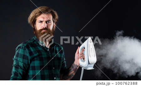 Iron an inspiration. new technology with high quality. homework and household. Steaming blue iron. happy man with iron. perfect husband duty. bearded male housekeeper. hipster ironing clothes Iron an inspiration. new technology with high quality. homework and household. Steaming blue iron. happy man with iron. perfect husband duty. bearded male housekeeper. hipster ironing clothes 100762388