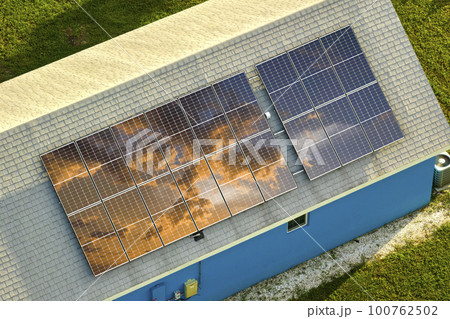 Aerial view of typical american building roof with rows of blue solar photovoltaic panels for producing clean ecological electric energy. Renewable electricity with zero emission concept 100762502