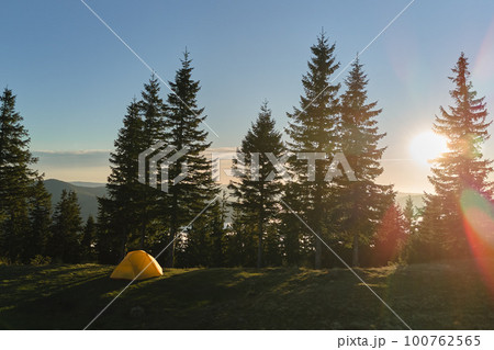 Aerial view of tourist camping tent on mountain campsite at bright sunny evening. Active tourism and hiking concept 100762565
