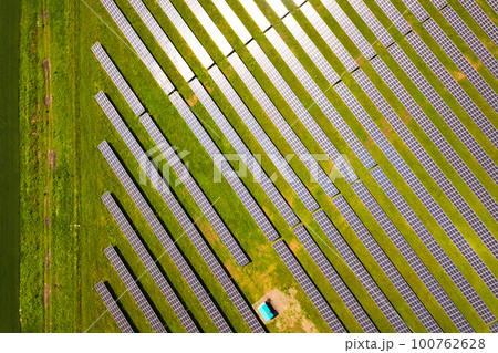 Aerial view of solar power plant on green field. Electric panels for producing clean ecologic energy. Aerial view of solar power plant on green field. Electric panels for producing clean ecologic energy. 100762628