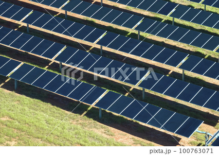 Aerial view of big sustainable electric power plant with many rows of solar photovoltaic panels for producing clean electrical energy. Renewable electricity with zero emission concept 100763071