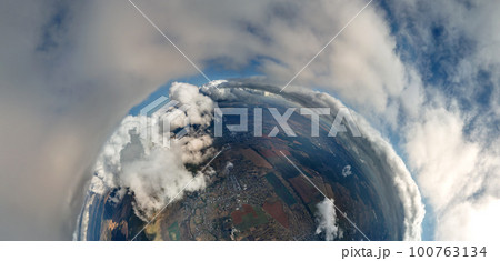 Aerial view from high altitude of little planet with distant city covered with puffy cumulus clouds flying by before rainstorm. Airplane point of view of landscape in cloudy weather 100763134