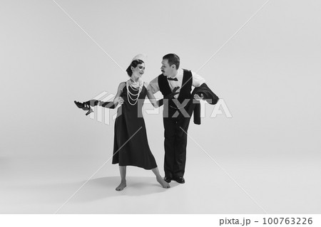 Adorable couple of dancers wearing chick vintage clothes talking about love. Relationship and music concept. Monochrome. 100763226