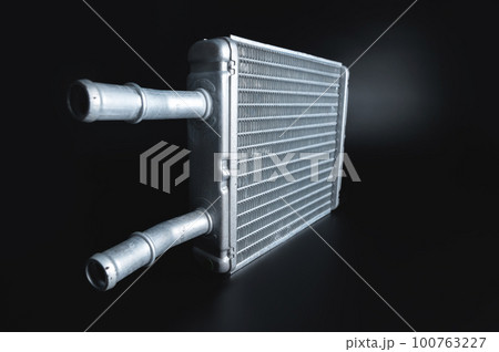 radiator of the heating and air conditioning system of the car, radiator of the car interior stove, close-up on a black background, selective focus 100763227