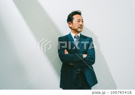 白バックでスーツを着た50代男性のポートレート 100765418