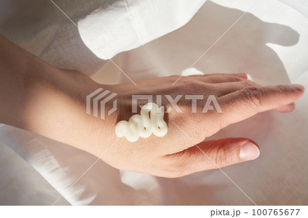 Photo of the texture of a moisturizing cream on the hand. 100765677
