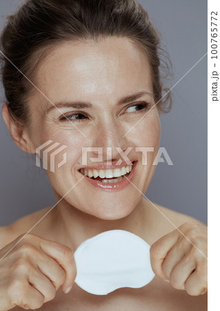 happy young woman with cotton pad on blue happy young woman with cotton pad on blue 100765772
