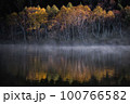 紅葉の朝に景色を反射している湯気が出る池 100766582