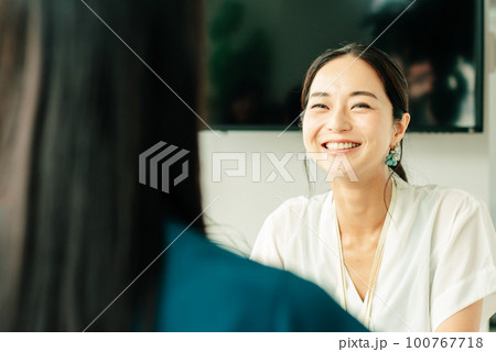 笑顔で会話する30代日本人女性 100767718