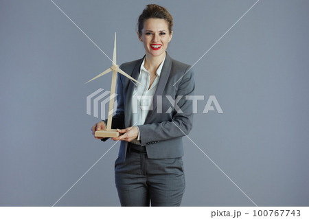 happy stylish female worker in gray suit isolated on gray happy stylish female worker in gray suit isolated on gray 100767743