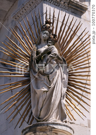 Virgin Mary with baby Jesus, statue on the corner of the facade of the San Michele in Foro Church in Lucca, Italy 100770370